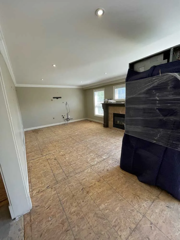 Same living room with the flooring removed down to the subfloor
