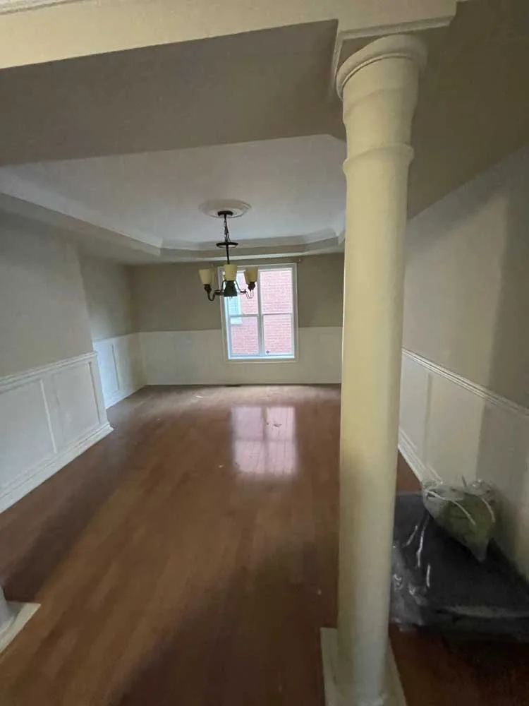 Dining room with columns, a chandelier and a hardwood floor before removal