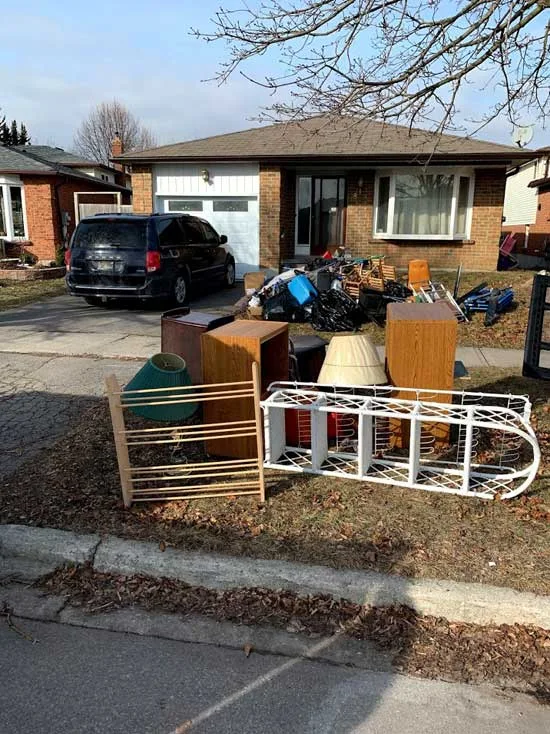Old chairs, a small table and other furniture left on a front lawn by the street